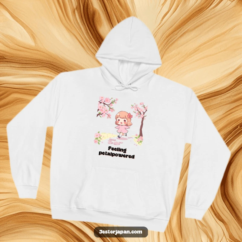 Funny hoodie featuring a character with rosy cheeks, skipping along a cherry blossom path, perfect for cozy spring vibes.