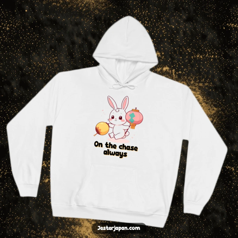 Funny hoodie illustrating a cute bunny character energetically chasing a rolling, illuminated festival lantern, radiating pure amusement and warmth.